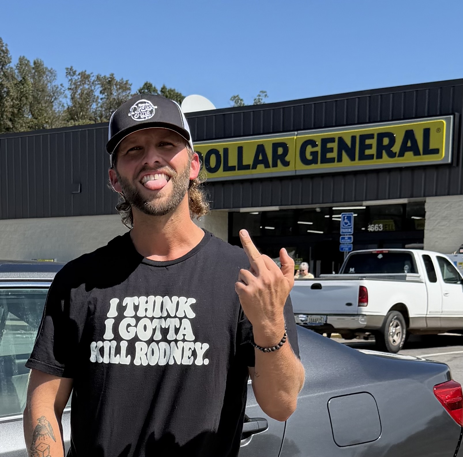 Dustin wearing his I Think I Gotta Kill Rodney T-shirt outside Dollar General.